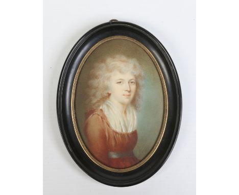 After Henry Raeburn an early 19th century oval ivory portrait miniature of a young woman wearing a dark red dress. In carved 