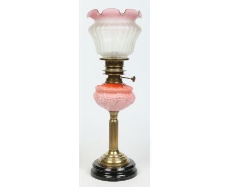 A Victorian brass based oil lamp with opaque moulded cranberry glass font and frosted shade, 58cm high total.   Condition Rep