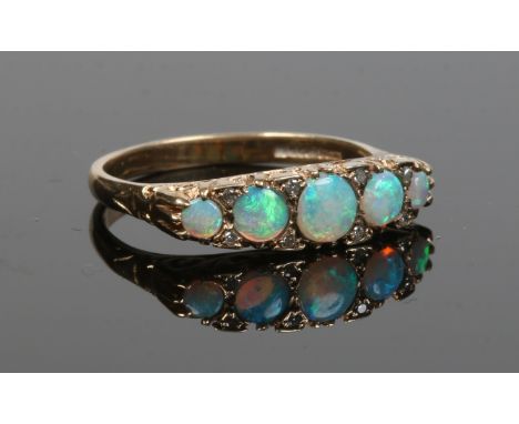 A 9 carat gold five stone opal ring, each stone interspersed  with a pair of diamonds, size T.   Condition Report. To be used