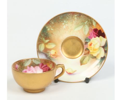 A Royal Worcester miniature cup and saucer. Gilded and decorated in coloured enamels with roses. Signed Twin, printed puce ma