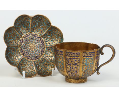 A 19th century Indian gilt metal fluted cup and saucer decorated with champleve enamel. Saucer 12.5cm wide.    Condition Repo