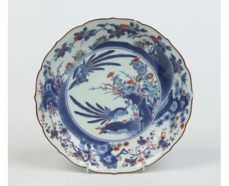 A 17th century Japanese Kakiemon type dish with lotus petal rim edged in brown enamel. Decorated in underglaze blue, overglaz