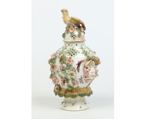 A Derby ovoid potpourri vase and cover. Moulded with a bird finial, twin mask handles and adorned with applied flowers. Paint