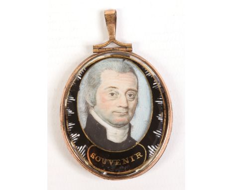 An early 19th century yellow metal mourning pendant set with a portrait miniature of a gentleman in verre églomisé mount insc