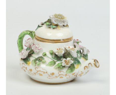 A Rockingham miniature novelty teapot and cover. With rustic handle and ornamented with applied flowers decorated in coloured