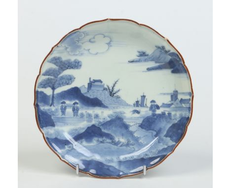 A 17th century Japanese Kakiemon type dish with lotus petal rim edged in brown enamel. Painted in underglaze blue with three 