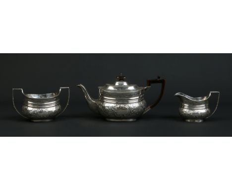 A Victorian silver three part tea service by Edward Barnard & Sons Ltd. Decorated with repousse work flowers and C scrolls, a