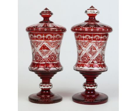 A pair of 19th century Bohemian etched ruby glass castlettes and covers. Decorated with panels of wild animals. Ground pontil