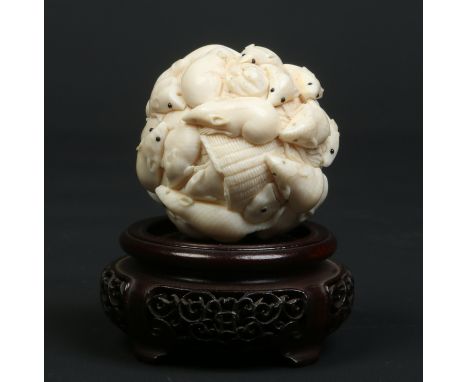 A Japanese Meiji period carved ivory okimono on hardwood plinth. Formed as a group of rats clambering over a basket of fish, 