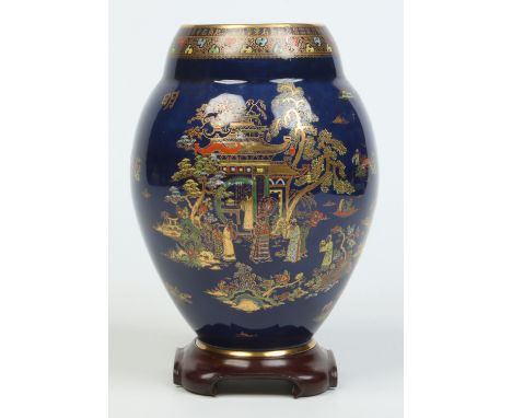 A large Carltonware ovoid vase on associated hardwood plinth. Powder blue ground, decorated in printed gilt and enamel with a