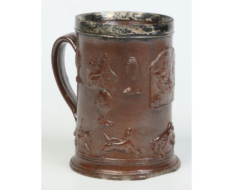 An early 19th century large salt glaze brown stoneware tankard, possibly Nottingham. With silver mounted rim, reeded strap ha