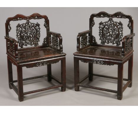 A pair of 19th century Chinese carved hardwood armchairs. With pierced roundel panels to the back rests depicting deer and bi