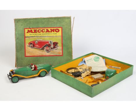 A vintage Meccano Ltd tin plate clockwork model of a motor car in original box with spares. With green livery with a figure s