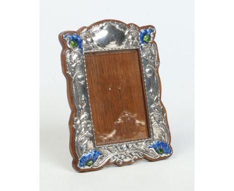 An Art Nouveau silver eizel photograph frame by Horton & Allday. Decorated in relief with stylized poppies and with later blu