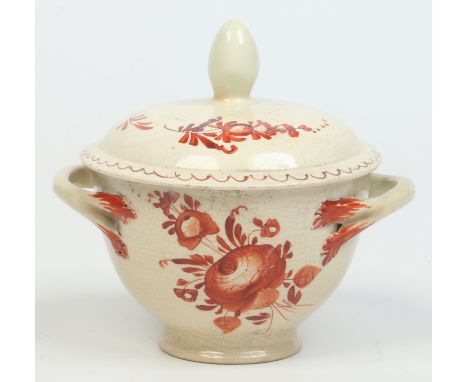 An 18th century creamware ecuelle and cover. With rustic strap handles and painted in red overglaze enamel with flower sprigs