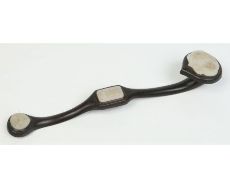 A Chinese carved hardwood ruyi sceptre. Ornamented with three celadon jade tablets carved with a dragon and phoenix, a deer a