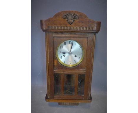 A 20th century oak wall clock, with silvered Arabic dial, having glazed door, H.53 W.28cm 