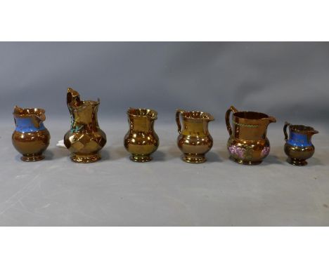A collection of six copper lustreware ceramic jugs of varying size, with floral decoration, largest H.20cm 