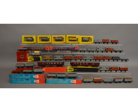 OO Gauge. 13 boxed Trix items of Rolling Stock including six Wagons and 7 maroon BR Coaches of various types, all appear G+ i