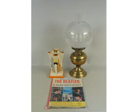 A brass oil lamp with glass shade, an Arthur Woods Art Deco vase plus a 1960's souvenir comic 'The Beatles in a Hard Days Nig