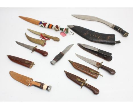 A collection of nine 20th century and later reproduction daggers to include African ceremonial, kukri and Jambiya, largest bl