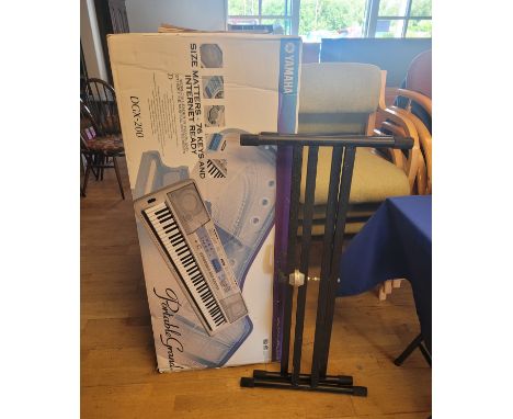 A Yamaha 'Portable Grand' electronic keyboard DGX-200, boxed with folding stand.
