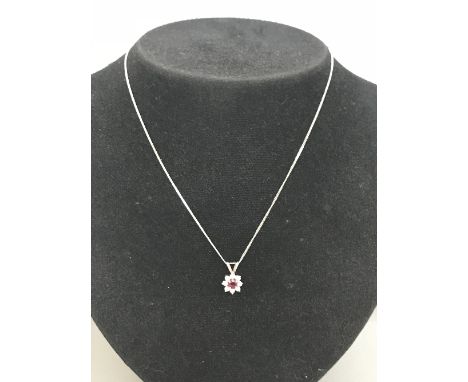 DIAMOND AND RUBY FLOWER STYLE PENDANT set in 9ct white gold with 16" 9ct white gold chain