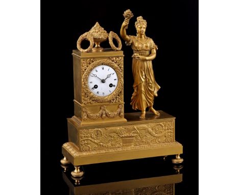 Classic fire-gilded richly decorated mantel clock with flower cup and wreaths on top, woman with bunch of ears of corn in her