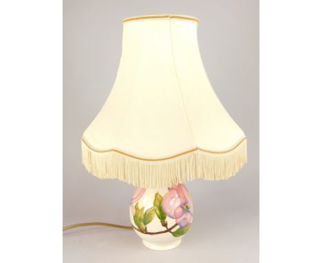 A Moorcroft tube lined pottery baluster shaped table lamp base, decorated with pink flowers, etc, with a shade, 46cm high ove