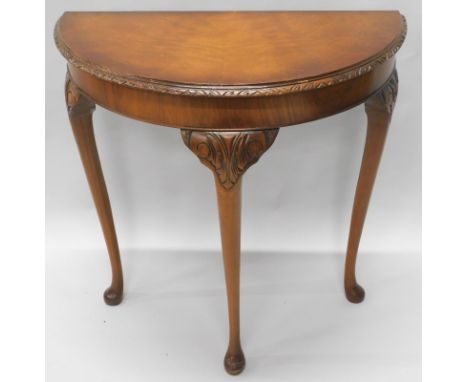 A walnut demi-lune console table, with a carved edge, on cabriole legs with pad feet, 74cm wide