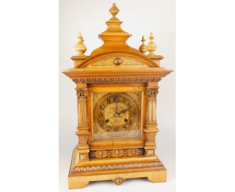 A late 19thC German walnut mantel clock, with pressed metal dial, the case carved with stylised scales egg and dart, and two 
