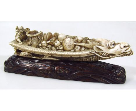 A Japanese carved and stained okimono figure group, of musicians in a dragon boat, signature to the base, 17cm long, with har