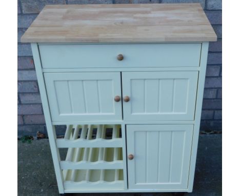 A modern light beech kitchen unit, with drawers and cupboards above wine rack