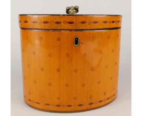An early 19thC satinwood oval tea caddy, the hinged lid inlaid with roundels and lozenges, surrounded by a central and oval b