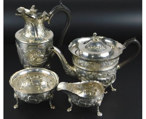 An Edward VII Irish silver four piece tea service, each embossed with foxes, swans, vines etc., on shaped legs, headed by lio