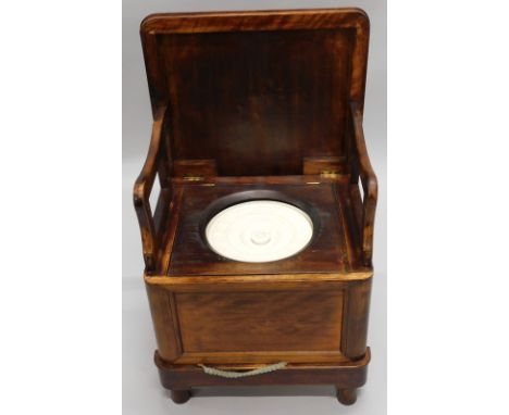 A satin walnut box commode, the padded seat enclosing a ceramic chamber pot and hinged arm supports, 52cm wide