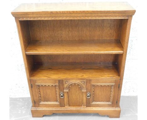 An Old Charm style type oak bookcase, with two panel doors, on bracket feet, 84cm wide