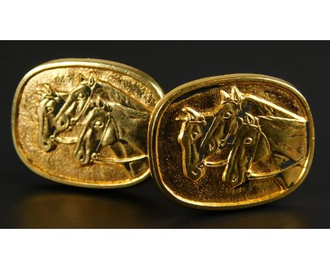 A pair of horse cufflinks, each on oval shield, set with three horses, yellow metal, unmarked, boxed. 