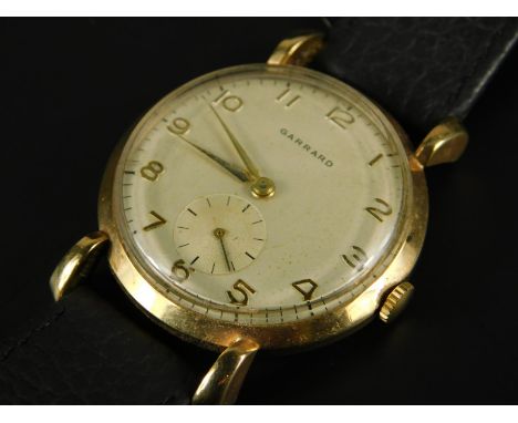 A Garrard gent's wristwatch, with circular watch head, yellow metal, marked 375, on a black leather strap, 28.5g all in. 