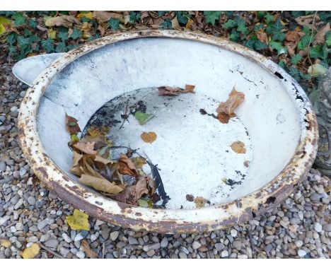 A large circular metal drinking trough