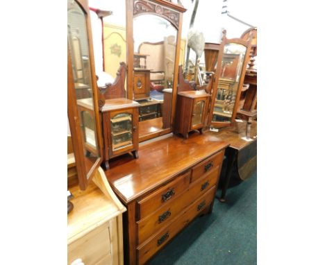 A late Victorian walnut dressing chest, with a central rectangular mirror, flanked by hinged further mirrors, the base with t