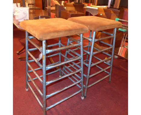 A pair of vintage gymnasts vaulting stools raised on metallic blue supports with makers label 