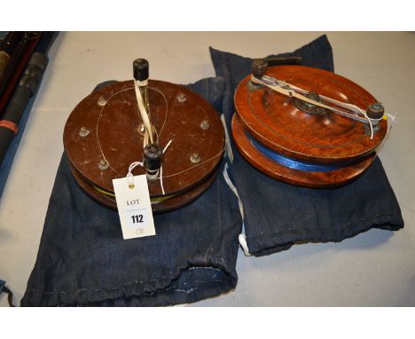 A large 7 1/2in. diameter mahogany and brass Scarborough reel with a line and a blue bag, and another large 8in. diameter Sca