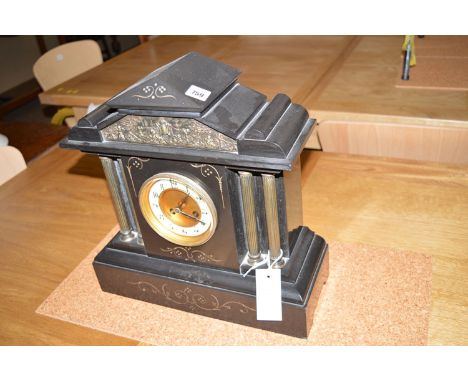 A Victorian mantel clock in slate case, fitted arabic dial.