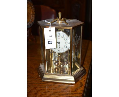 A perpetual motion clock by Kundo, in brass case.