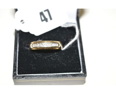 A nine stone diamond ring, each of the princess cut diamonds in channel setting, on 18ct. yellow gold shank, ring size R.