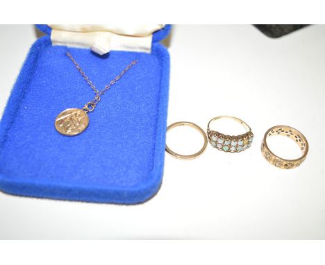 A white stone set eternity ring; a 9ct. gold wedding band; a 9ct. gold St. Christopher medal; and an opal set ring on 9ct. go