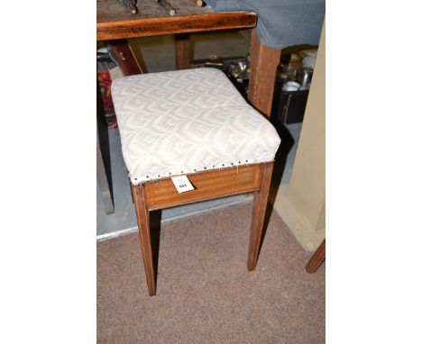 An Edwardian inlaid mahogany piano stool with upholstered hinged top, raised on square tapering legs.