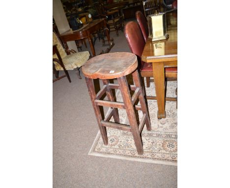 An early 20th Century stained wood stool with shaped seat, raised on rounded square legs joined by stretchers.