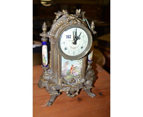 A brass and printed case ceramic French style mantel clock, decorated with flowers and other motifs.